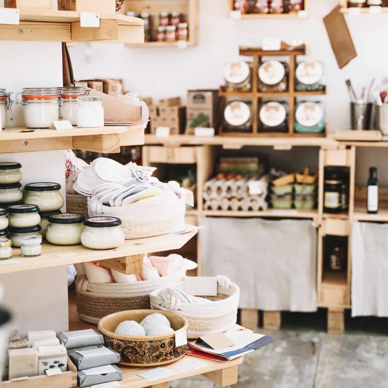 Zero waste shop interior details. Wooden shelves with different food goods and personal hygiene or cosmetics products in plastic free grocery store. Eco-friendly shopping at local small businesses